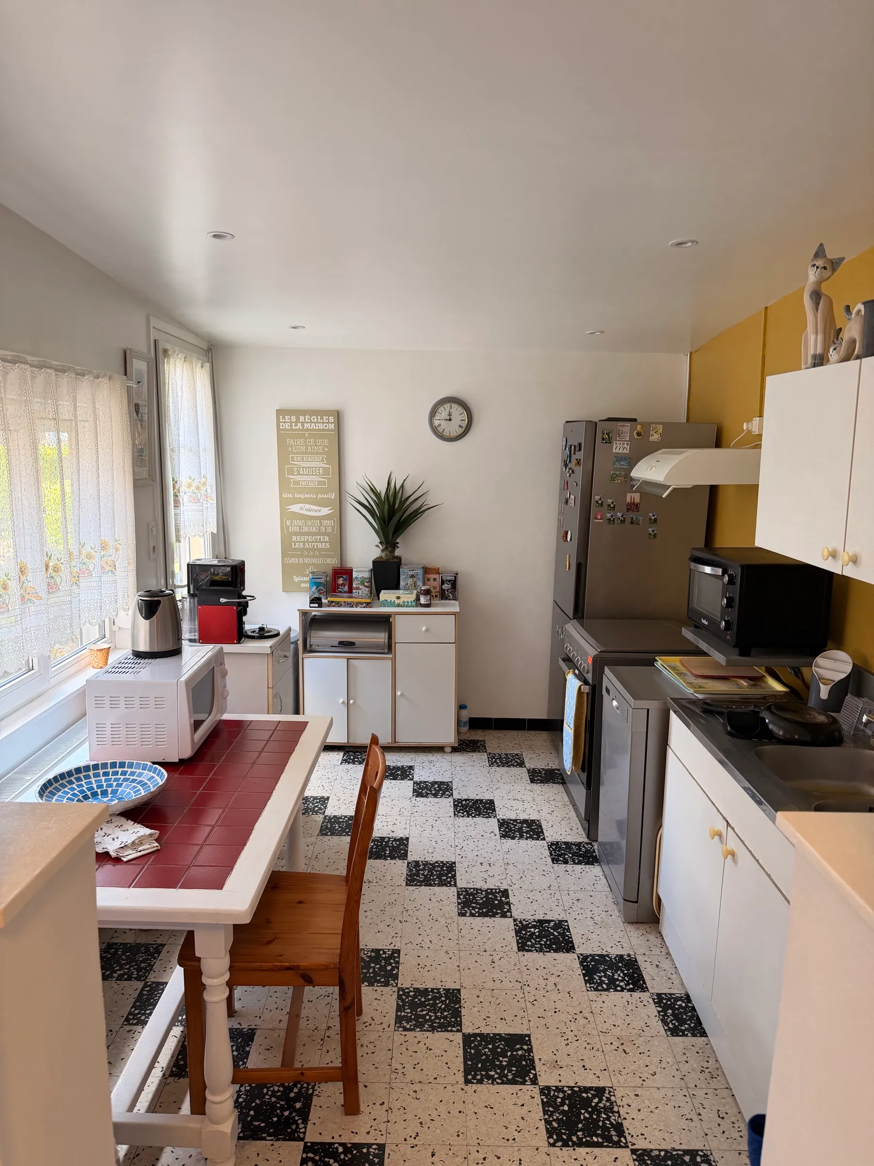 La cuisine avant travaux - meubles blancs datés et sol granito en damier noir et blanc