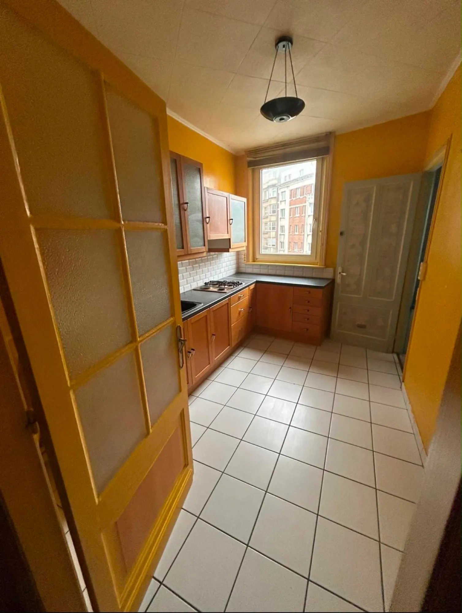 L'ancienne cuisine avant rénovation - meubles vieillissants et carrelage daté