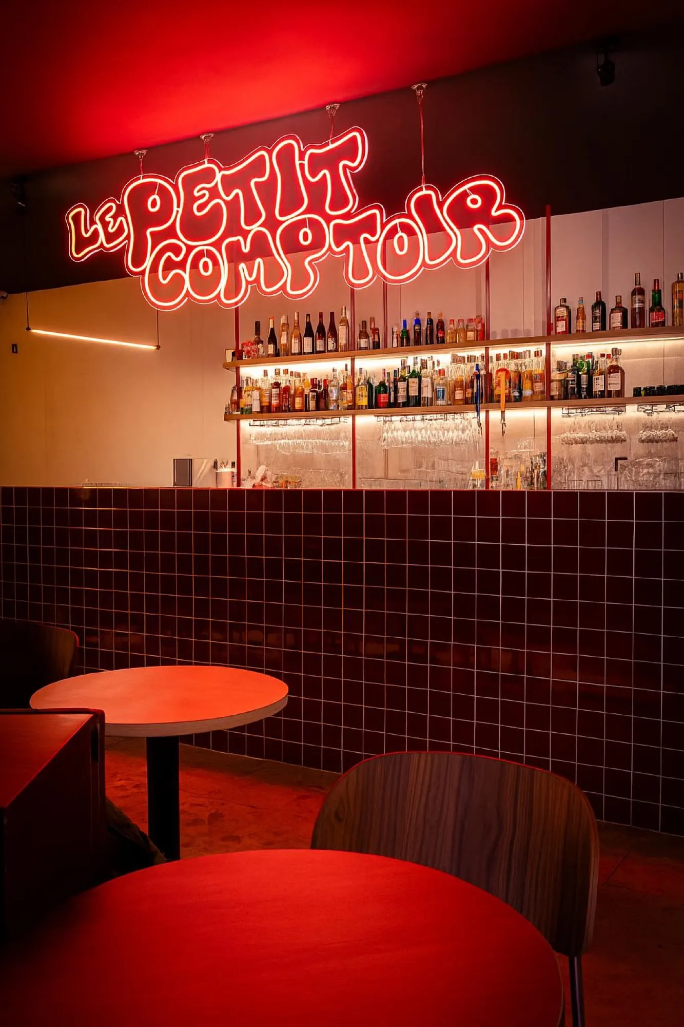 Le comptoir et l'enseigne néon « Le Petit Comptoir » dans le bar à Lille