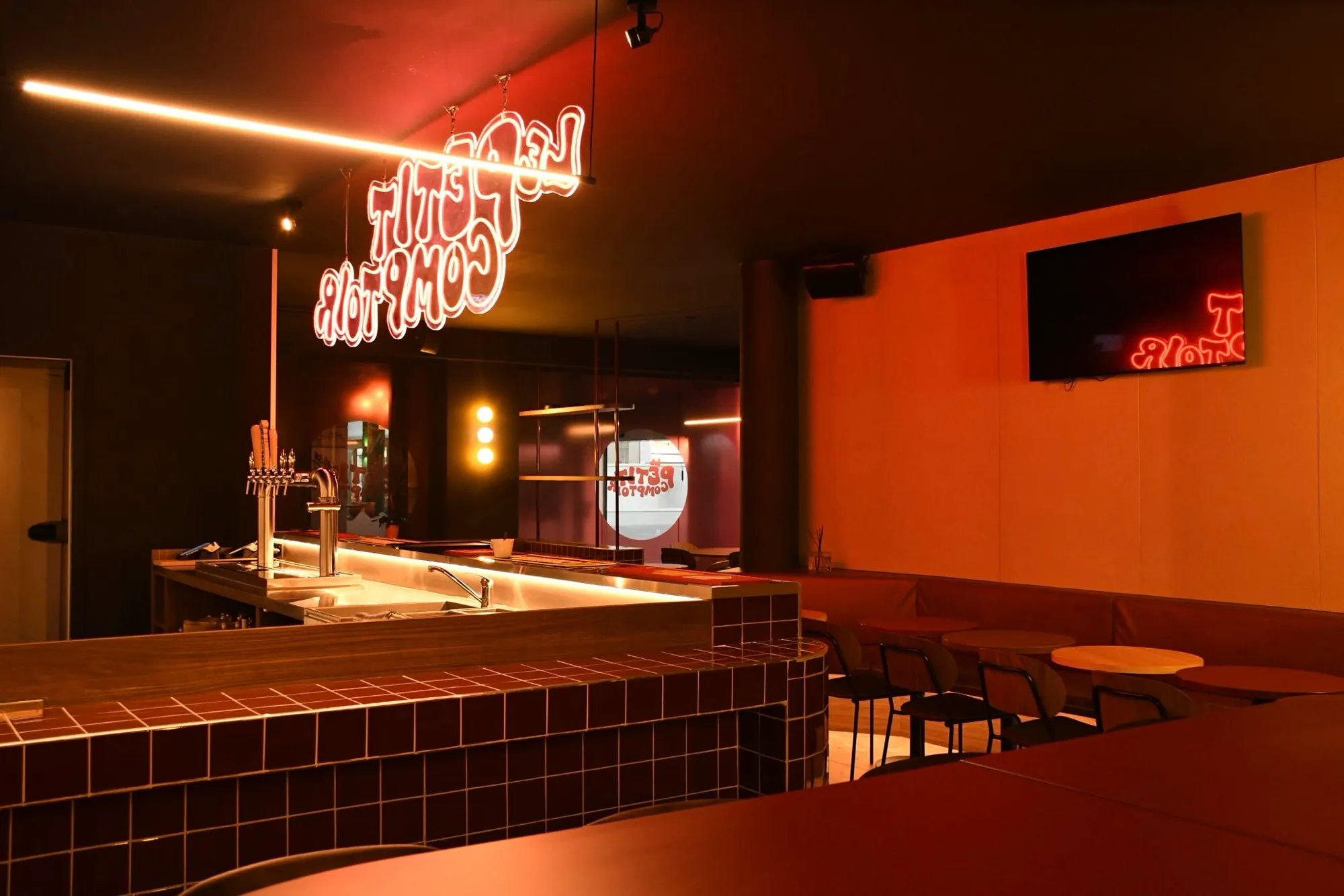 Le comptoir du bar avec enseigne lumineuse, aménagement par Studio Astrid Buyse à Lille
