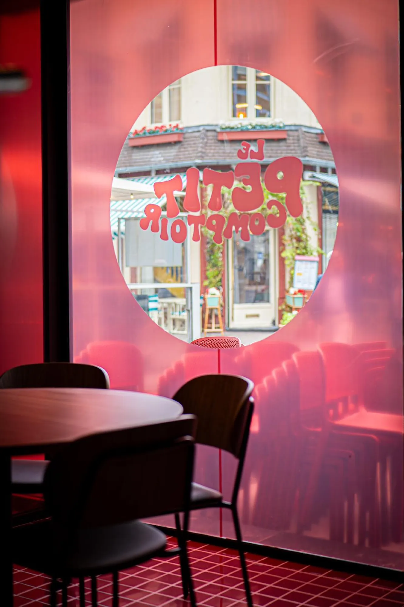 Coin salle du bar avec vitrine ronde signée et tables rondes en bois