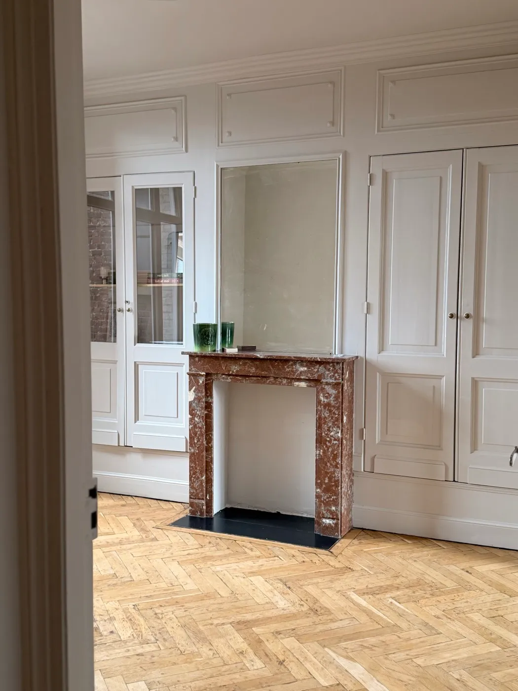 Salon de l'appartement rénové à Lille - cheminée en marbre et parquet en point de Hongrie